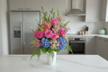 FLower arrangement in tall white vase with mix flowers 