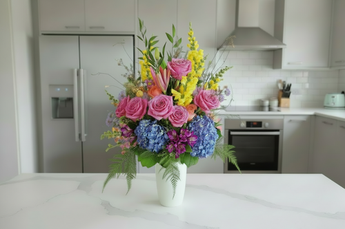 FLower arrangement in tall white vase with mix flowers 