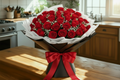 Bouquet of red roses in a white vase on a wooden table with a kitchen background