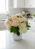 Bouquet of flowers in a white vase on a marble surface with a blurred background