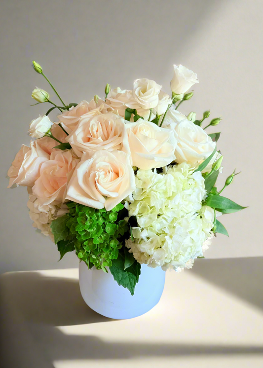 Bouquet of flowers in a white vase on a marble surface with a blurred background